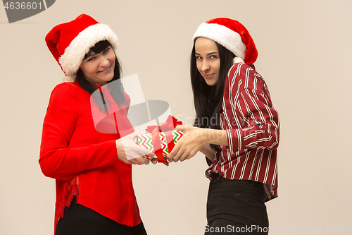 Image of Happy family in Christmas sweater posing on a red background in the studio.