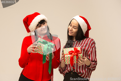 Image of Happy family in Christmas sweater posing on a red background in the studio.