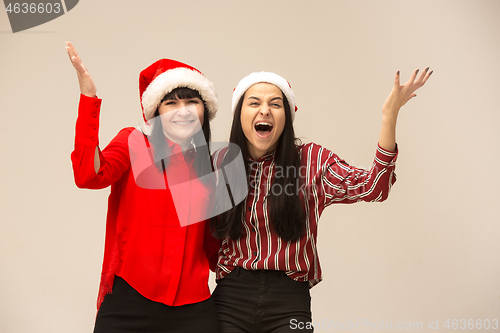 Image of Happy family in Christmas sweater posing on a red background in the studio.