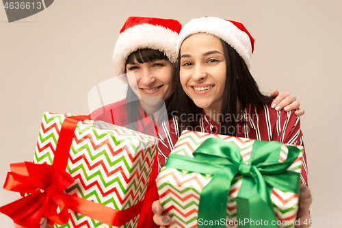 Image of Happy family in Christmas sweater posing on a red background in the studio.