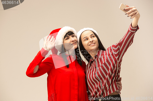 Image of Happy family in Christmas sweater posing on a red background in the studio.