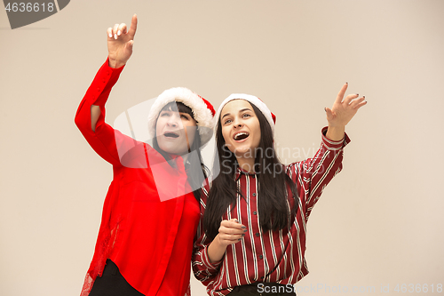 Image of Happy family in Christmas sweater posing on a red background in the studio.