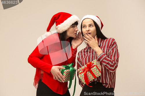 Image of Happy family in Christmas sweater posing on a red background in the studio.