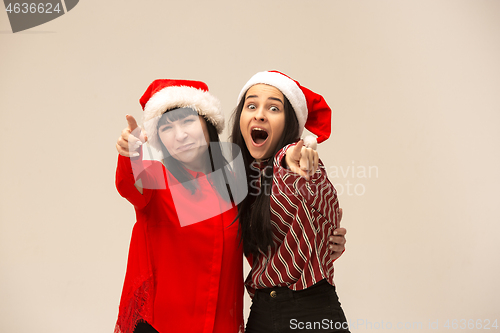 Image of Happy family in Christmas sweater posing on a red background in the studio.