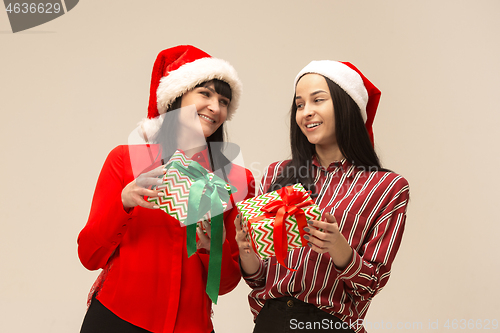 Image of Happy family in Christmas sweater posing on a red background in the studio.