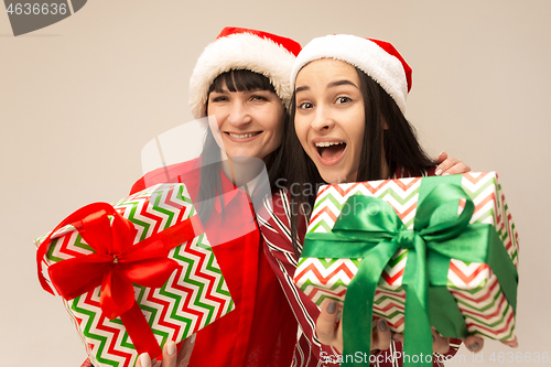 Image of Happy family in Christmas sweater posing on a red background in the studio.