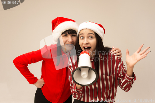 Image of Happy family in Christmas sweater posing on a red background in the studio.