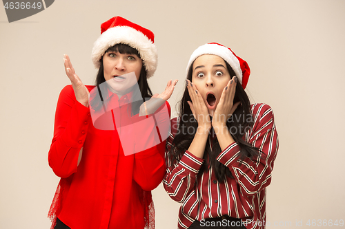 Image of Happy family in Christmas sweater posing on a red background in the studio.