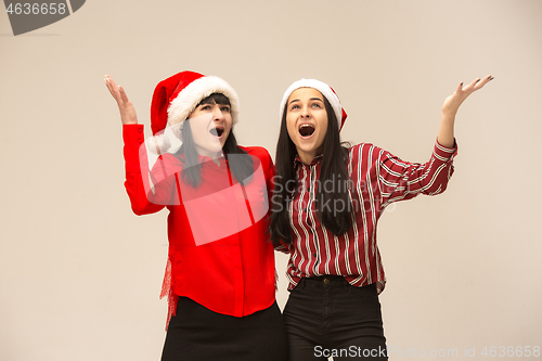 Image of Happy family in Christmas sweater posing on a red background in the studio.