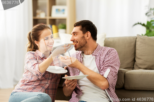 Image of happy couple eating pizza at home