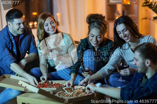 Image of friends eating pizza and drinking wine at home