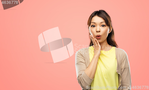 Image of surprised asian woman over grey background