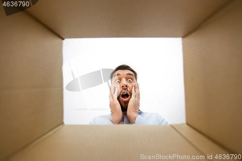 Image of shocked man looking into open parcel box