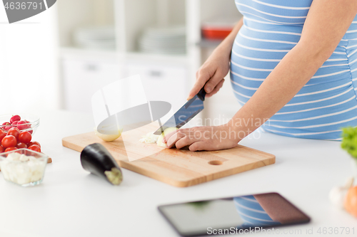 Image of close up of pregnant woman cooking food at home