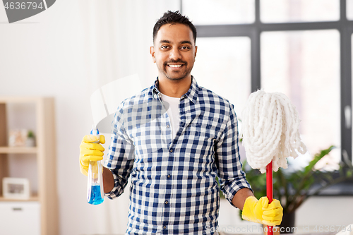 Image of indian man with mop and detergent cleaning at home