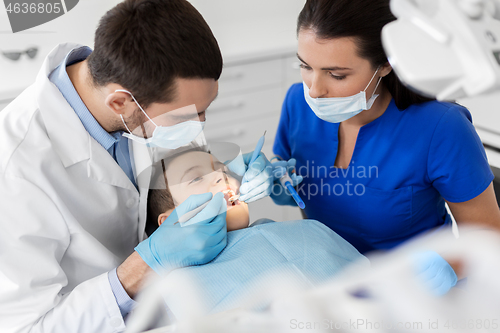 Image of dentist checking for kid teeth at dental clinic