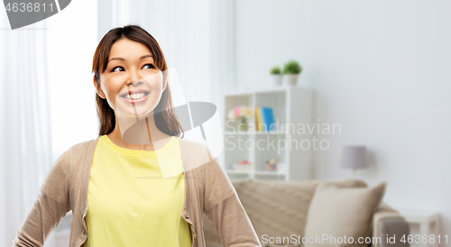 Image of happy asian woman looking up at home