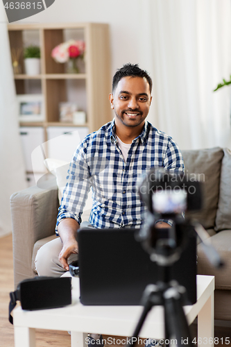 Image of male blogger with camera videoblogging at home