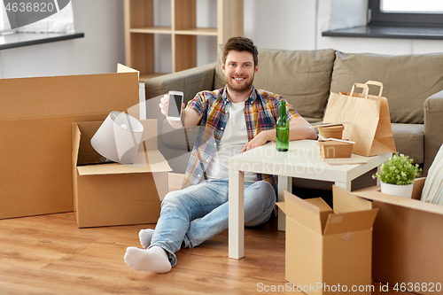 Image of man with smartphone and takeaway food moving