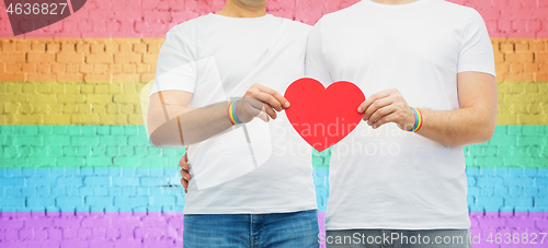 Image of couple with gay pride rainbow wristbands and heart