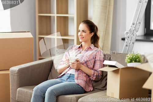 Image of woman moving to new home and drinking coffee