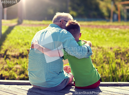 Image of grandfather and grandson hugging on berth