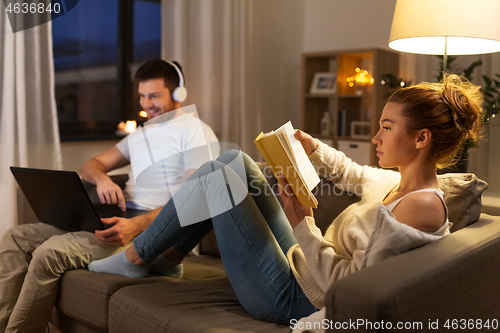 Image of couple with laptop computer and book at home