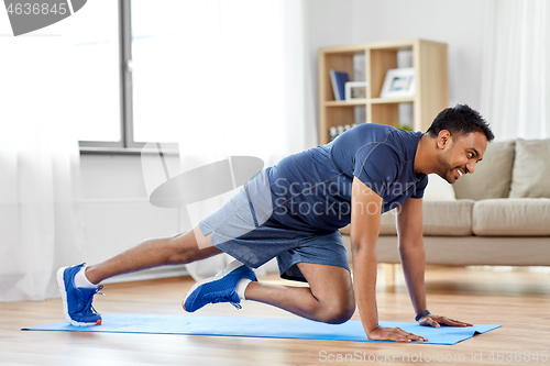 Image of man doing running plank exercise at home