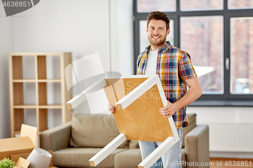 Image of happy man with table moving to new home