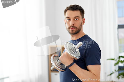 Image of man exercising with dumbbell at home