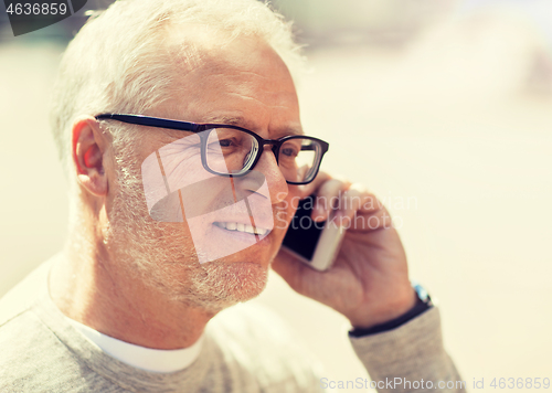 Image of happy senior man calling on smartphone in city