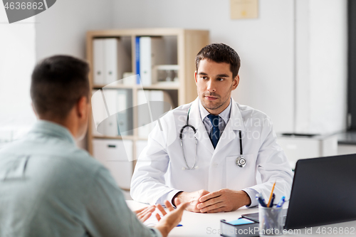 Image of doctor with laptop and male patient at hospital