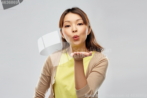 Image of young asian woman sending blow kiss