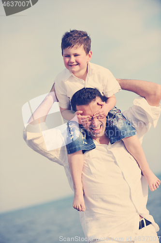 Image of happy father and son have fun and enjoy time on beach