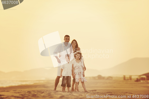 Image of happy young family have fun on beach at sunset