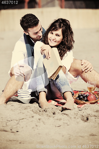 Image of young couple enjoying  picnic on the beach