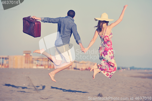 Image of couple on beach with travel bag