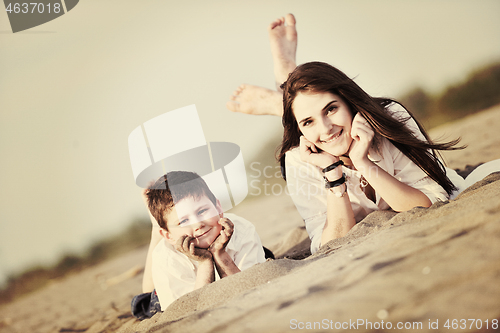 Image of mom and son relaxing on beach