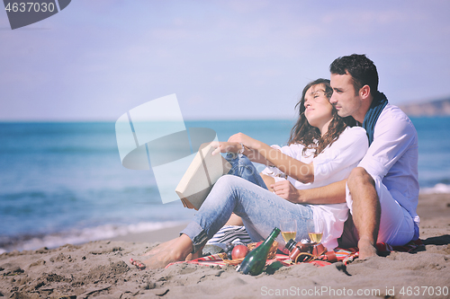 Image of young couple enjoying  picnic on the beach