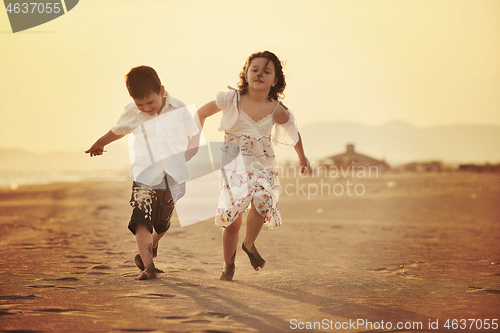 Image of happy young family have fun on beach at sunset