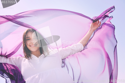 Image of beautiful young woman on beach with scarf