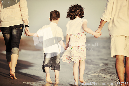 Image of happy young family have fun on beach at sunset