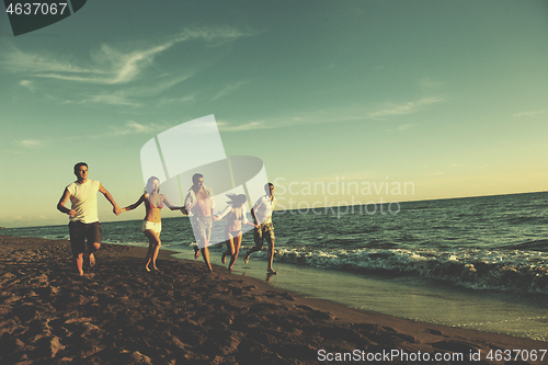 Image of people group running on the beach