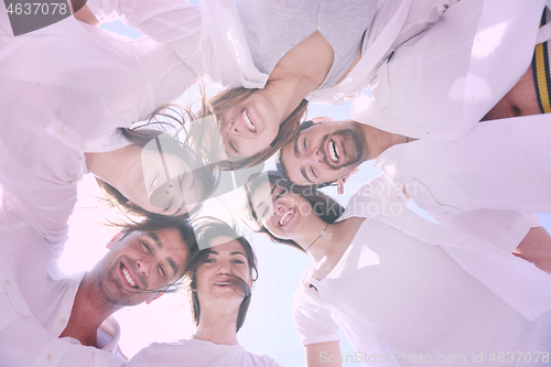 Image of Group of happy young people in circle at beach