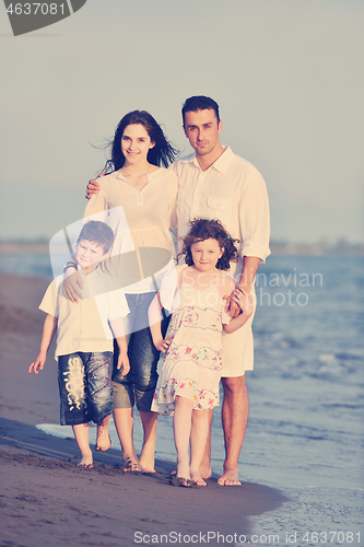 Image of happy young family have fun on beach at sunset