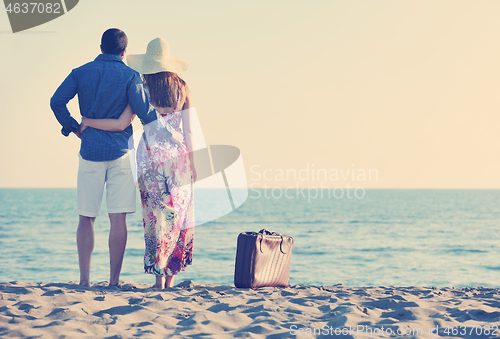 Image of couple on beach with travel bag