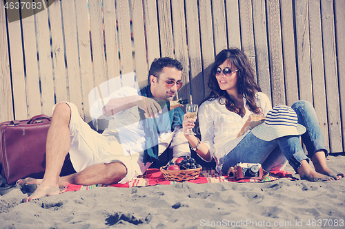 Image of young couple enjoying  picnic on the beach