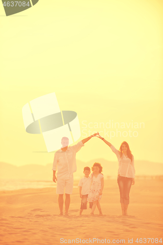 Image of happy young family have fun on beach at sunset