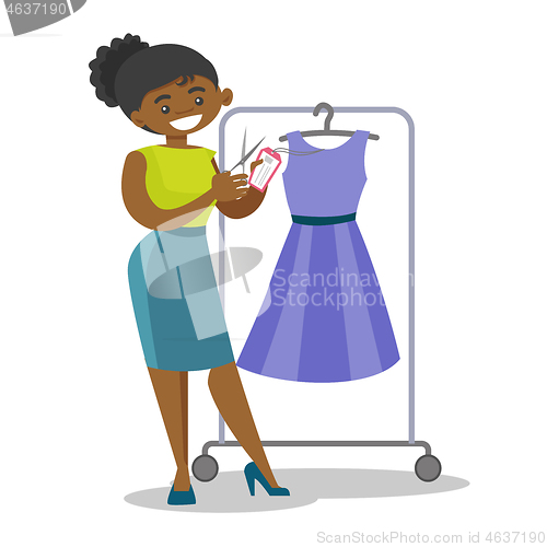 Image of African woman cutting price tag off new dress.