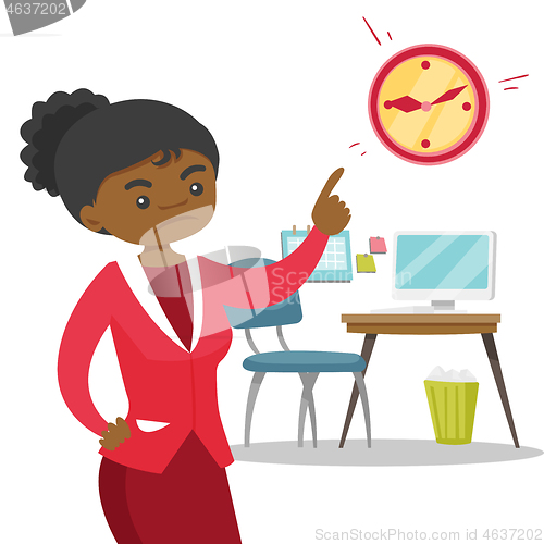 Image of Angry african employer pointing to time on clock